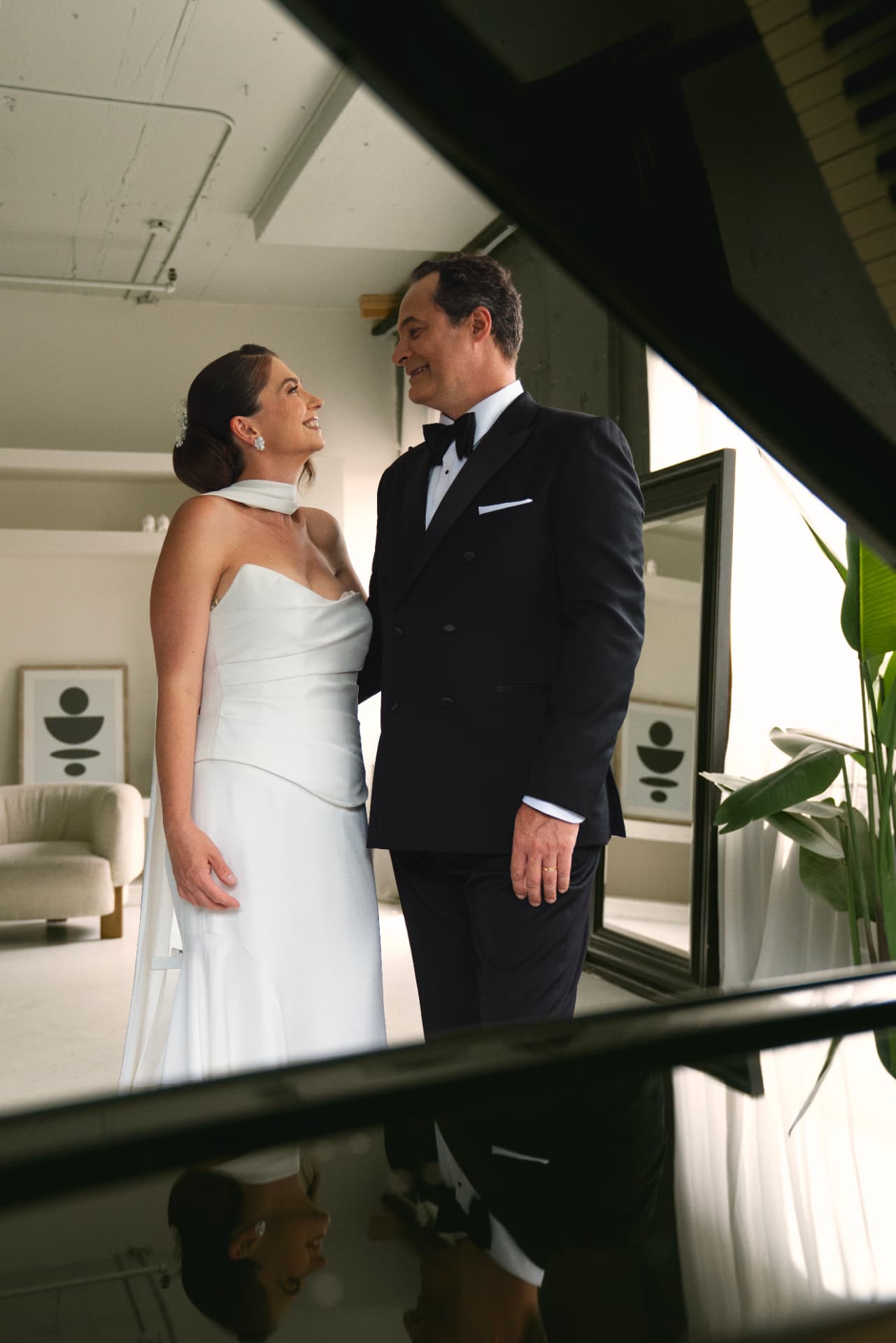 Le couple se regardant, robe blanche et smoking, en studio