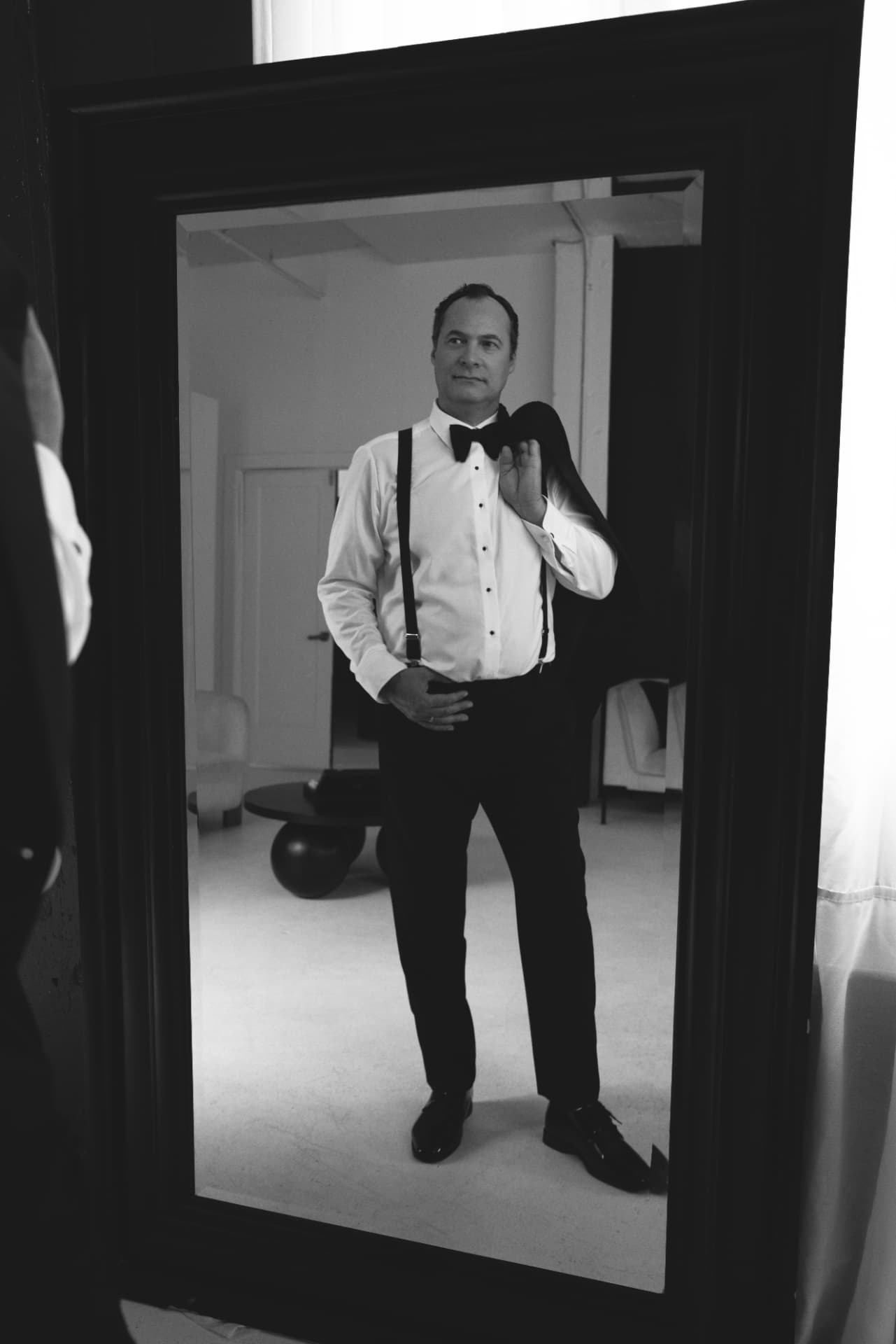 Le marié dans le miroir, veston sur l'épaule